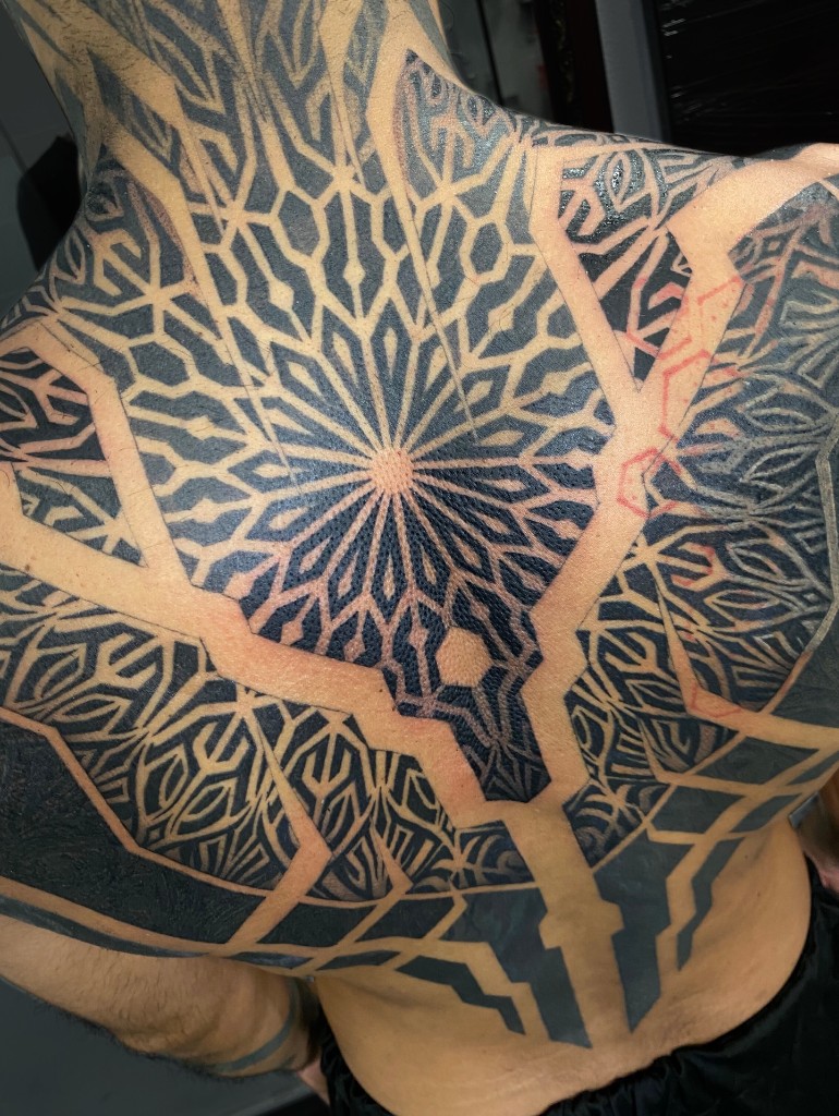 Composición geométrica tatuada en la espalda.