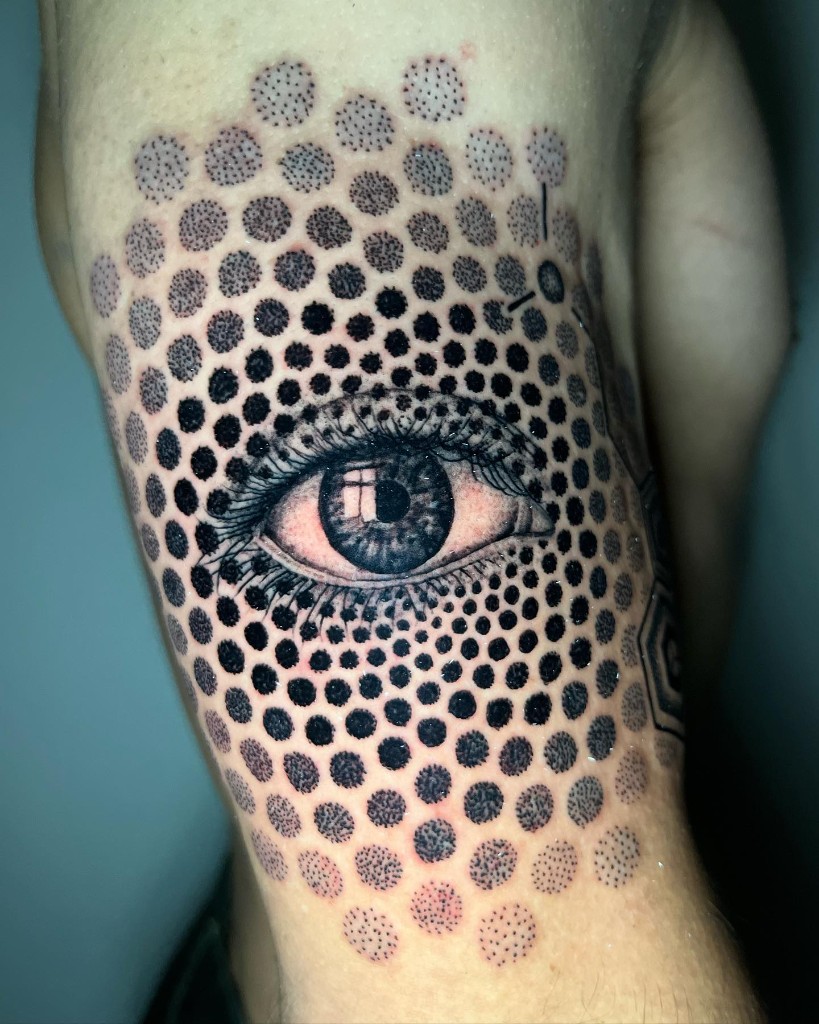 Ojo tatuado con un campo de puntillismo.